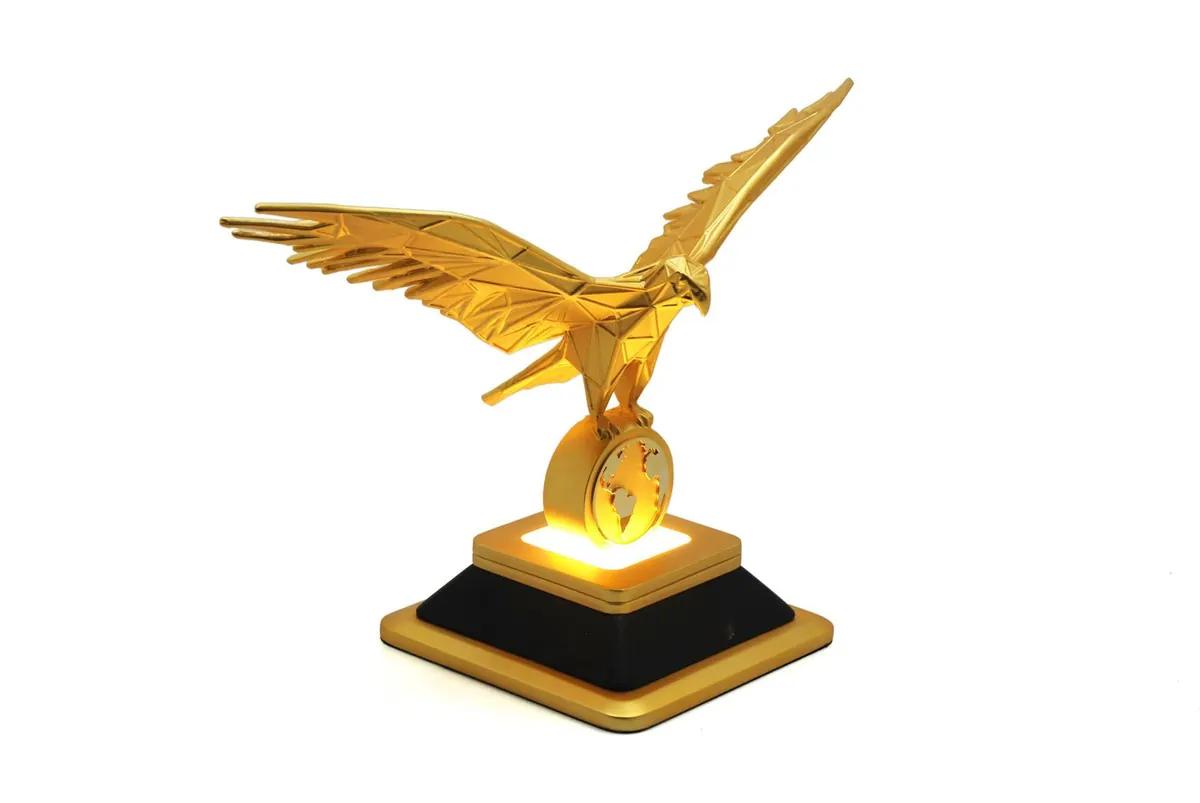 Gold falcon sculpture on a black plinth